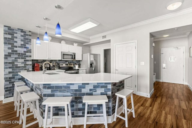 kitchen with hanging light fixtures, a kitchen breakfast bar, stainless steel appliances, and kitchen peninsula