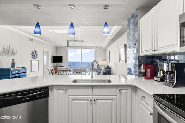 kitchen featuring sink, decorative light fixtures, appliances with stainless steel finishes, kitchen peninsula, and white cabinets