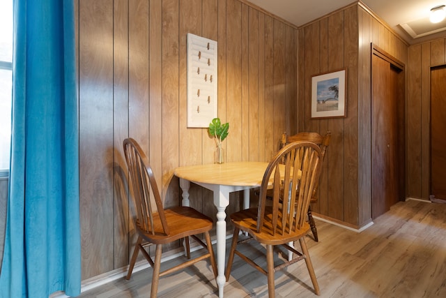 dining space featuring wooden walls and light hardwood / wood-style flooring