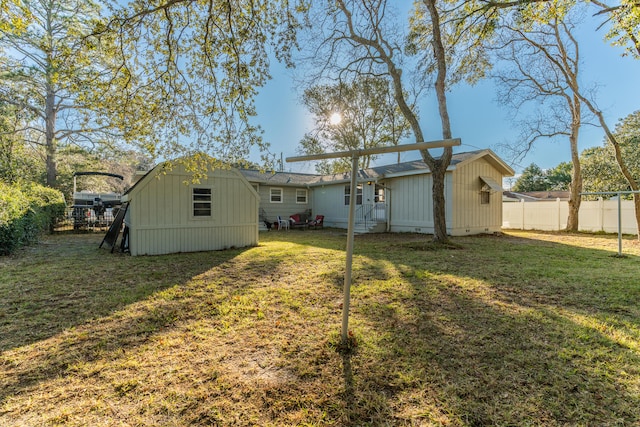 back of property featuring a yard and a shed