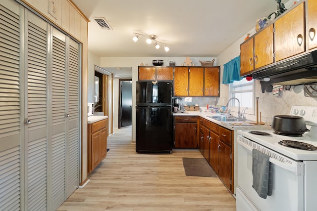 kitchen featuring black refrigerator, white electric range, sink, decorative backsplash, and light hardwood / wood-style flooring