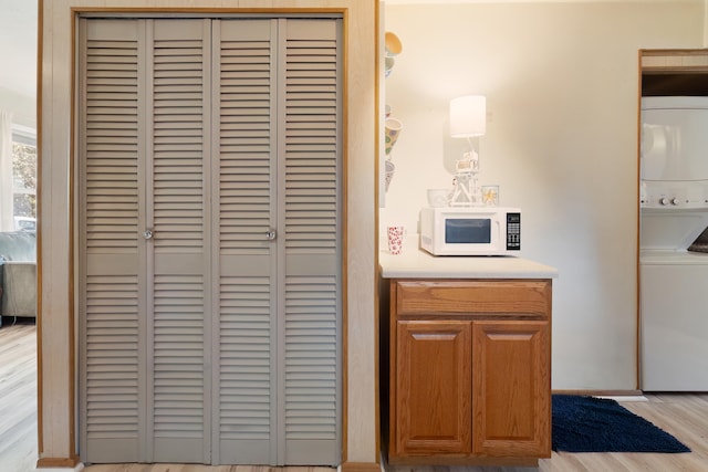 interior details featuring stacked washing maching and dryer and wood-type flooring