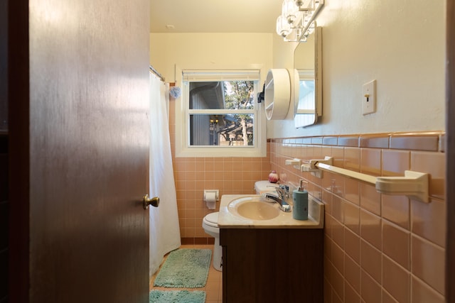 bathroom with vanity, toilet, tile patterned flooring, and tile walls