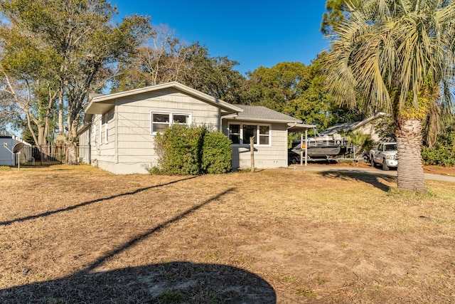 rear view of house with a carport and a yard