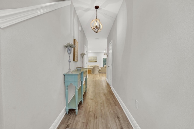 hallway featuring a notable chandelier and light hardwood / wood-style flooring