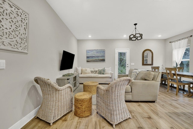 living room with a chandelier and light hardwood / wood-style floors