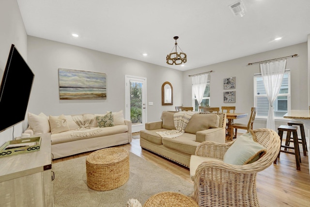 living room featuring a notable chandelier and light hardwood / wood-style flooring