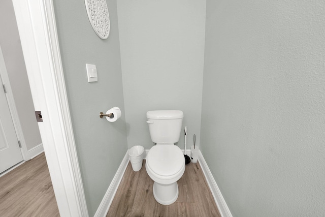 bathroom featuring hardwood / wood-style flooring and toilet