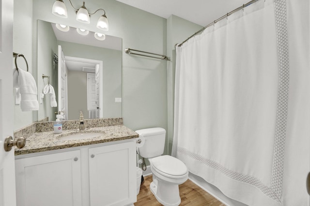 bathroom with wood-type flooring, toilet, and vanity