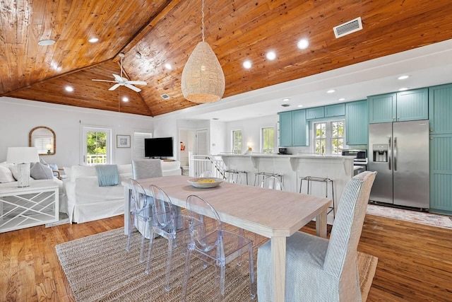 dining space with wooden ceiling, high vaulted ceiling, light hardwood / wood-style flooring, and a wealth of natural light