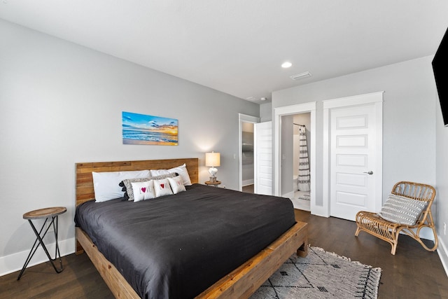 bedroom featuring dark wood-type flooring and connected bathroom