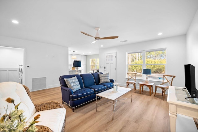 living room featuring ceiling fan and light wood-type flooring