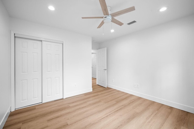 unfurnished bedroom with light hardwood / wood-style floors, a closet, and ceiling fan