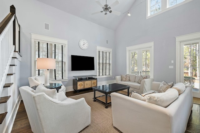 living room featuring dark hardwood / wood-style flooring, high vaulted ceiling, and ceiling fan