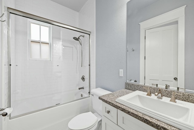 full bathroom with enclosed tub / shower combo, vanity, and toilet