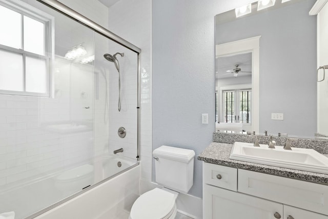 full bathroom with enclosed tub / shower combo, vanity, toilet, and a wealth of natural light