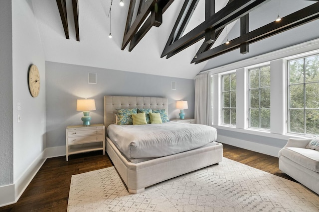 bedroom with dark wood-type flooring, multiple windows, and vaulted ceiling with beams