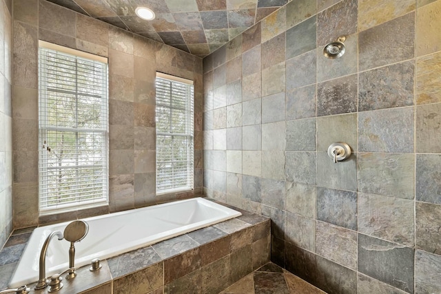 bathroom with a relaxing tiled tub