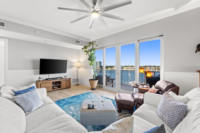 tiled living room with ornamental molding and ceiling fan