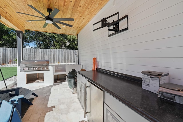 view of patio featuring ceiling fan, an outdoor kitchen, and a grill