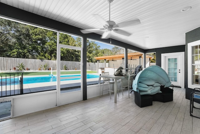 unfurnished sunroom featuring ceiling fan