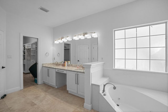 bathroom with tile patterned flooring, vanity, and a tub to relax in