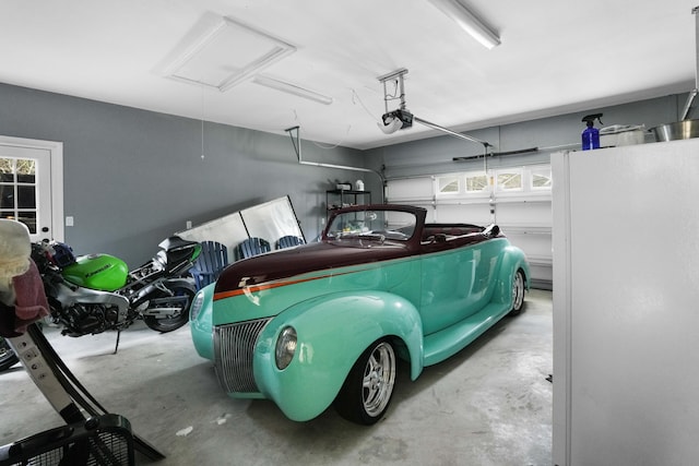 garage with a garage door opener and white refrigerator