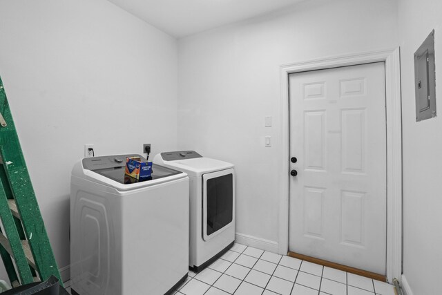 laundry area with light tile patterned flooring, electric panel, and washer and clothes dryer