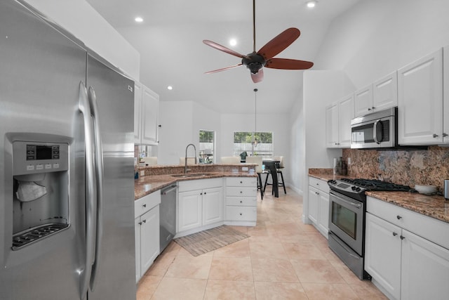 kitchen with dark stone countertops, sink, white cabinets, and appliances with stainless steel finishes