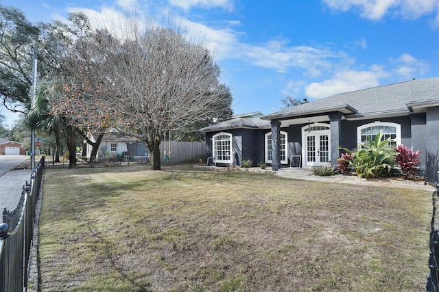 exterior space featuring a front lawn and french doors