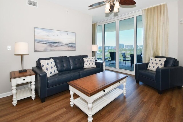 living room featuring dark wood-type flooring, ceiling fan, and expansive windows