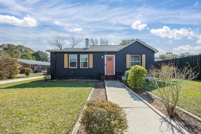 view of front of home with a front lawn, a chimney, and fence