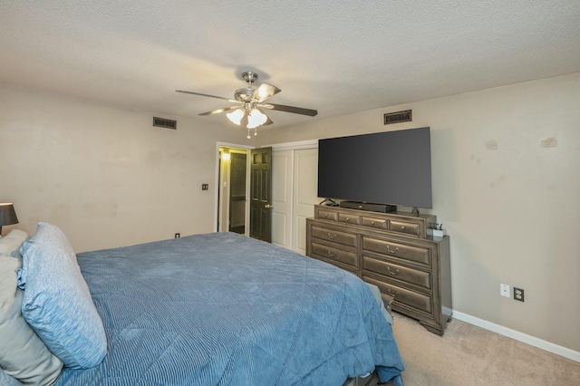 bedroom with light colored carpet, a textured ceiling, ceiling fan, and a closet