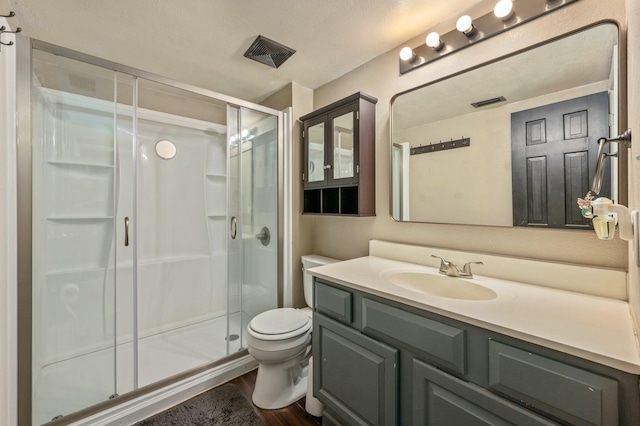 bathroom with walk in shower, vanity, toilet, and hardwood / wood-style floors