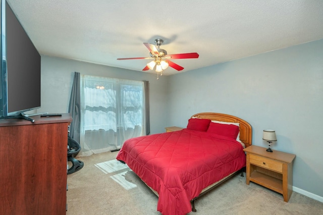 carpeted bedroom featuring a textured ceiling and ceiling fan