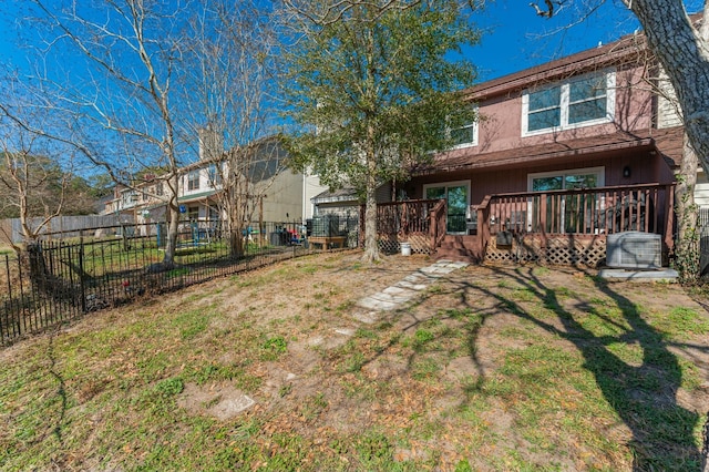 rear view of property with a wooden deck and a lawn