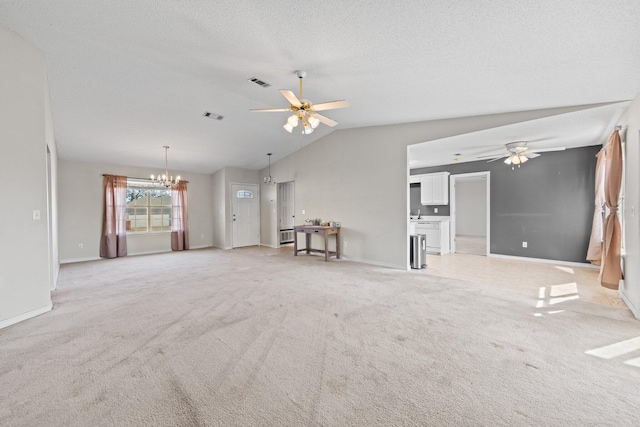 unfurnished living room featuring light carpet, ceiling fan with notable chandelier, vaulted ceiling, and a textured ceiling