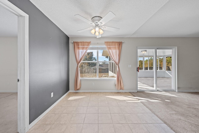 carpeted empty room with a textured ceiling and ceiling fan