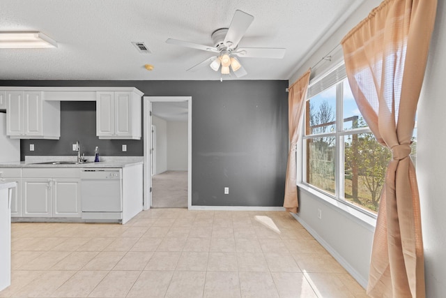 kitchen featuring white cabinetry, sink, ceiling fan, white dishwasher, and a textured ceiling