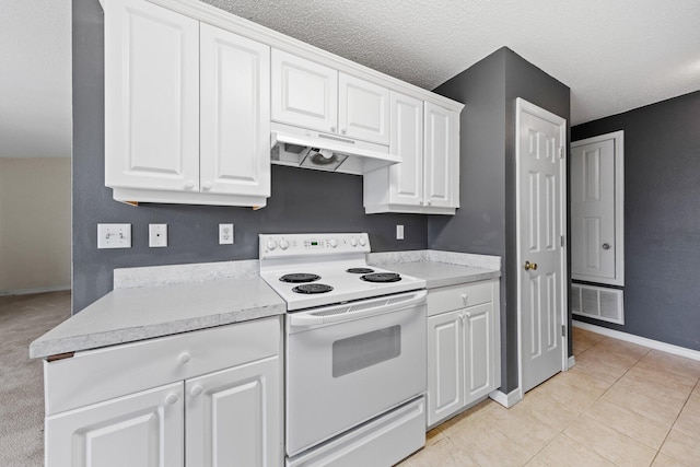 kitchen with light tile patterned floors, electric range, a textured ceiling, and white cabinets