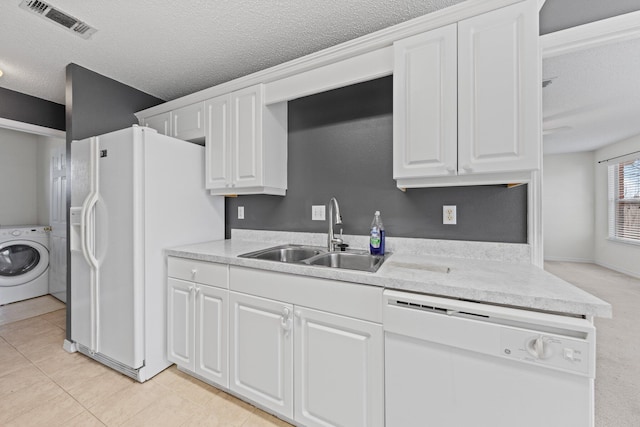 kitchen featuring sink, white cabinetry, a textured ceiling, white appliances, and washer / clothes dryer