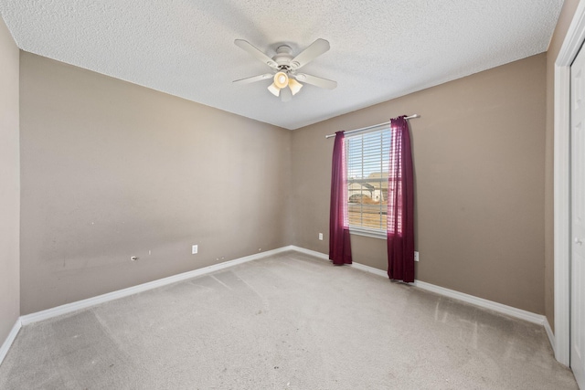 unfurnished room featuring ceiling fan, light carpet, and a textured ceiling