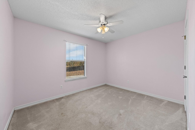 carpeted spare room with a textured ceiling and ceiling fan