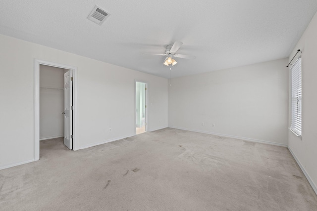 carpeted empty room with a textured ceiling and ceiling fan