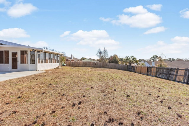 view of yard with a sunroom and a patio