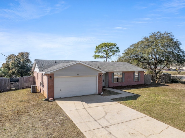 ranch-style house featuring a garage, central AC, and a front lawn