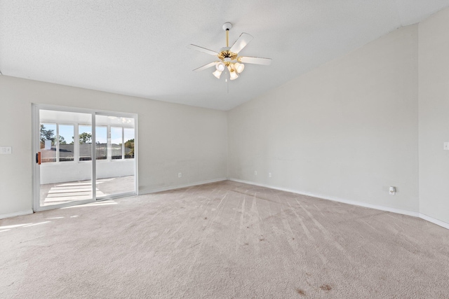 empty room with ceiling fan, lofted ceiling, light carpet, and a textured ceiling