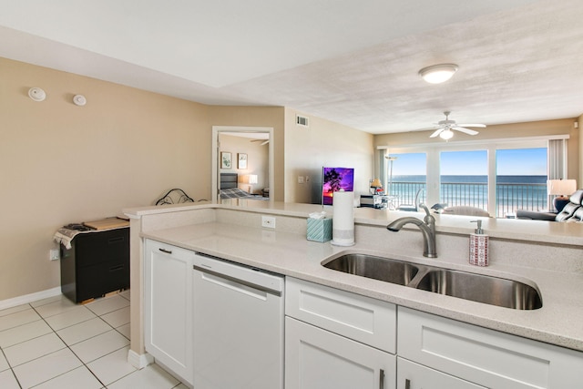 kitchen featuring sink, light tile patterned floors, dishwasher, ceiling fan, and white cabinetry