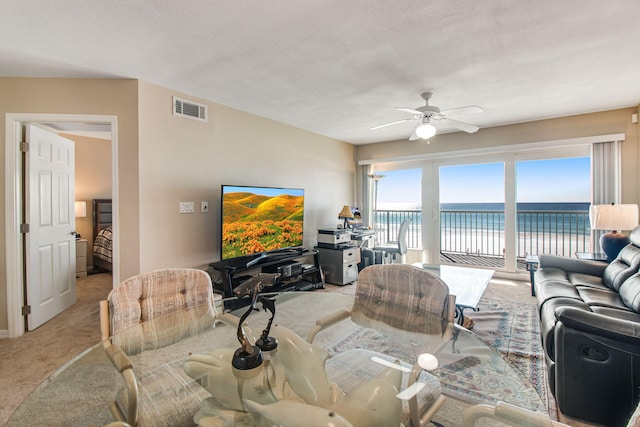 living room featuring light carpet, a textured ceiling, and ceiling fan