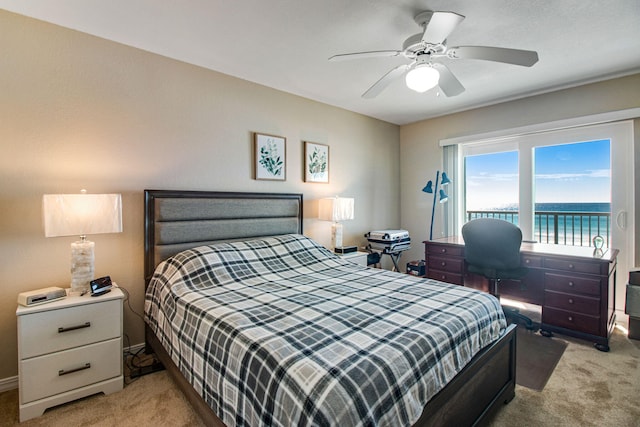 carpeted bedroom with a water view, ceiling fan, and access to outside